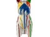 une figurine de chien aux couleurs vives posée sur une surface blanche