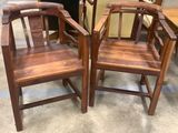 two wooden chairs sitting next to each other in a room