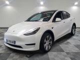 the white tesla model y is parked in the garage