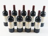 six bottles of red wine lined up in a row on a white surface