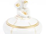 figurine en porcelaine représentant un singe assis sur une boîte blanche