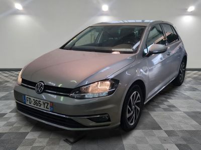 La Volkswagen Golf argentée est garée dans une pièce dont le sol est en damier.