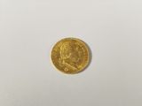 a close up of a gold coin on a white surface