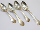 six silver spoons sitting on top of a white surface