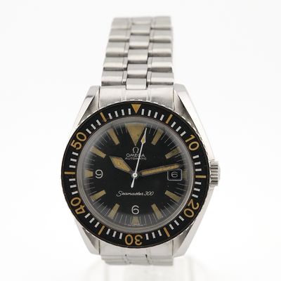 l'image d'une montre noire et or sur une surface blanche