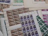 a lot of stamps on a table with a red table cloth