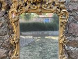 un miroir accroché à un mur de pierre, devant un mur de pierre