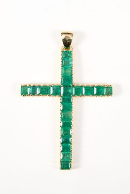 un gros plan d'un pendentif en forme de croix verte sur fond blanc