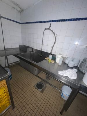 une cuisine avec un évier et beaucoup de vaisselle sur le plan de travail