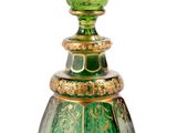 une image représentant un flacon de parfum en verre vert sur fond blanc