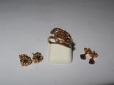 a gold ring and earring set on a white surface