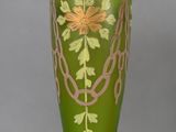 a green vase with a gold decoration on it