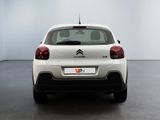 the rear end of a white citrole parked in a white room