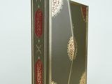 une image représentant un livre vert dont la couverture est ornée d'un motif rouge et or