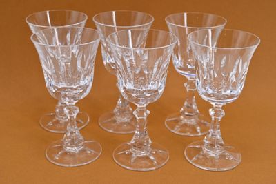 four empty wine glasses sitting on a table with a brown background