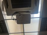 un climatiseur posé sur un sol carrelé, près d'une fenêtre