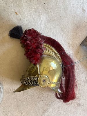 a gold helmet with a red feather on top of it