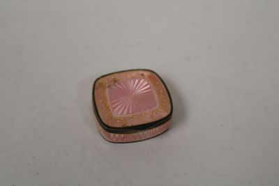 a small pink box sitting on a white surface