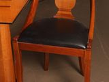 a wooden table with a black leather chair next to it