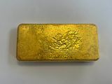 a gold bar sitting on top of a white surface