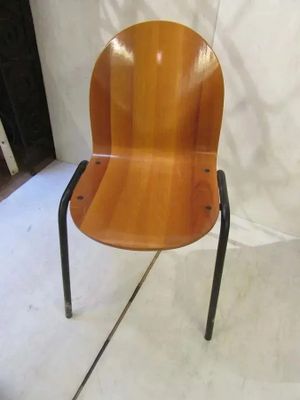 une chaise en bois aux pieds noirs posée sur un sol blanc