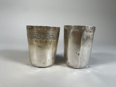 deux tasses en argent ornées de motifs sur fond blanc
