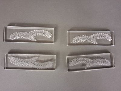 four clear glass trays with etched leaves and leaves on them