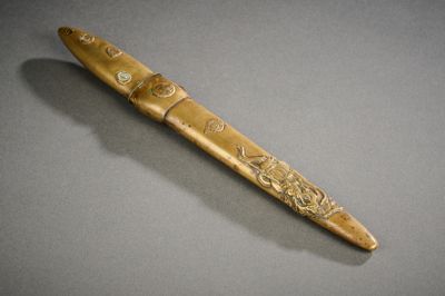 un gros plan d'un stylo en bois posé sur une surface grise