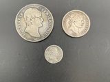 three silver coins sitting next to each other on a black surface