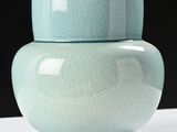 a blue vase sitting on a white table with a black background