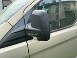 une camionnette blanche garée sur un parking à côté d'un bâtiment