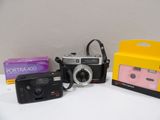 two cameras and a camera case sitting on a table