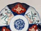 a blue and white plate with flowers and birds on it