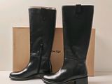 black leather boots with zippers and a box on a white surface