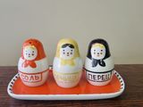 three salt and pepper shakers on a tray on a table