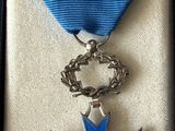 a blue and silver medal in a box with a blue ribbon