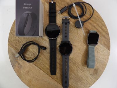 a wooden table with a couple of watches and a charger on it