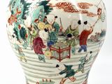 a vase with a painting on it sitting on a table