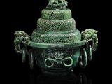 un gros plan d'un vase vert posé sur une surface noire
