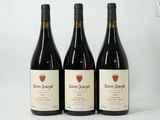 trois bouteilles de vin sont posées sur une surface blanche