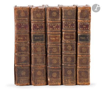 six old books are lined up in a row on a white surface