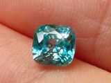 une image montrant un gros plan de la main d'une personne tenant un diamant bleu