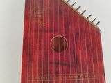 un vieil instrument rouge posé sur une table blanche