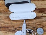 a nintendo wii remote and accessories laid out on a wooden floor