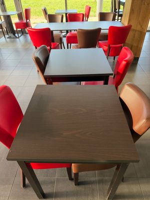 des tables et des chaises dans un restaurant donnant sur un champ verdoyant