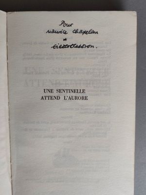 un livre ouvert, sur lequel figurent des caractères noirs, posé sur une table