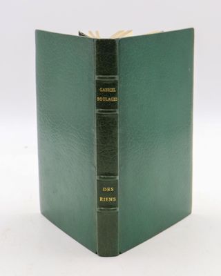 an old book with a green cover sitting on top of a white table