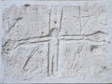 relief représentant une croix sculpté dans un mur de pierre d'une église