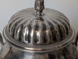 a silver pot with a lid sitting on a table