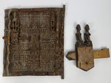 une photo d'une porte en bois ornée de sculptures, adossée à un mur